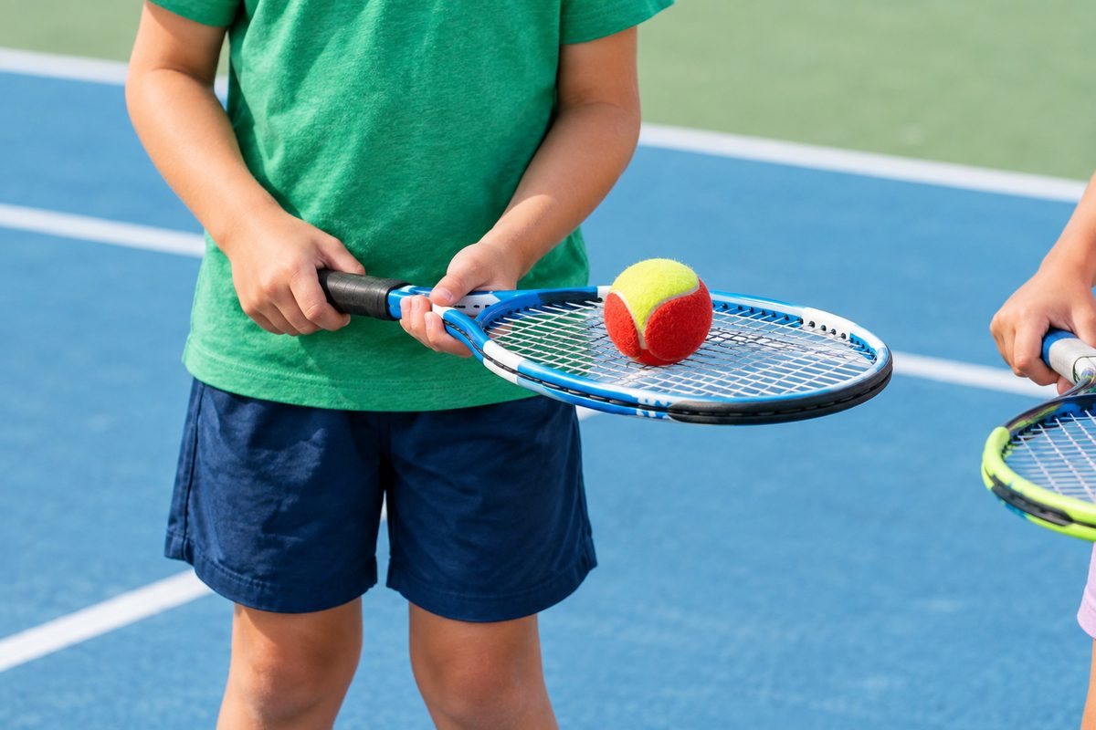 A tennis racket and ball held on court